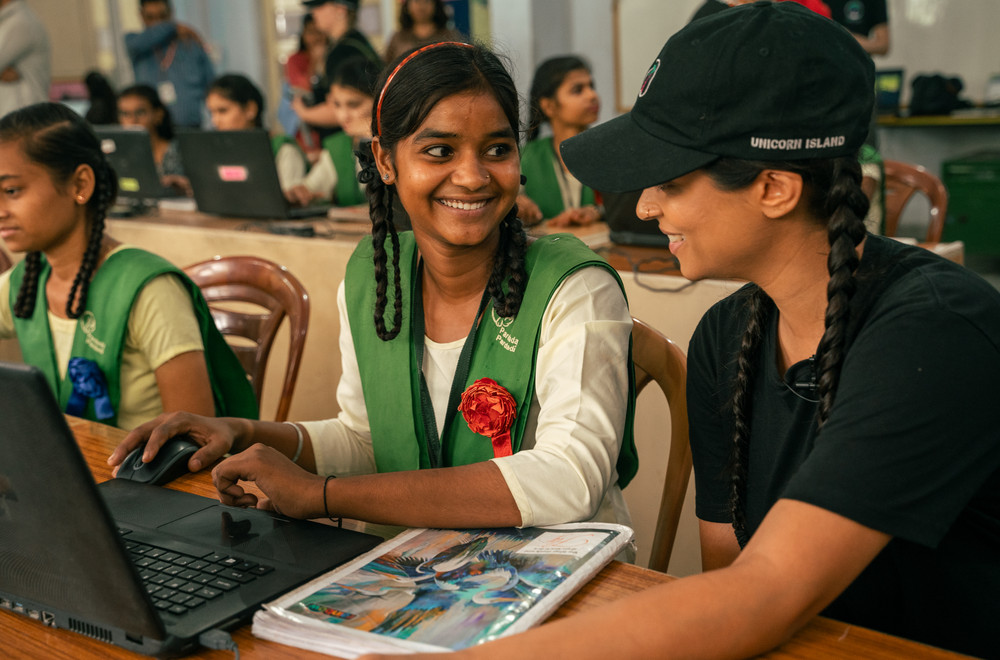 Lilly Singh with a girl at a school computer